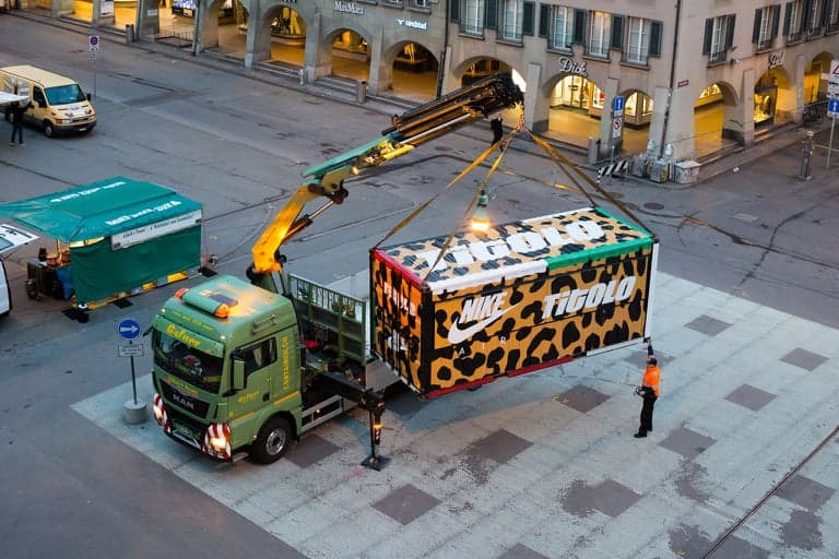 Kran-LKW platziert einen Eventcontainer in einer Schweizer Stadt